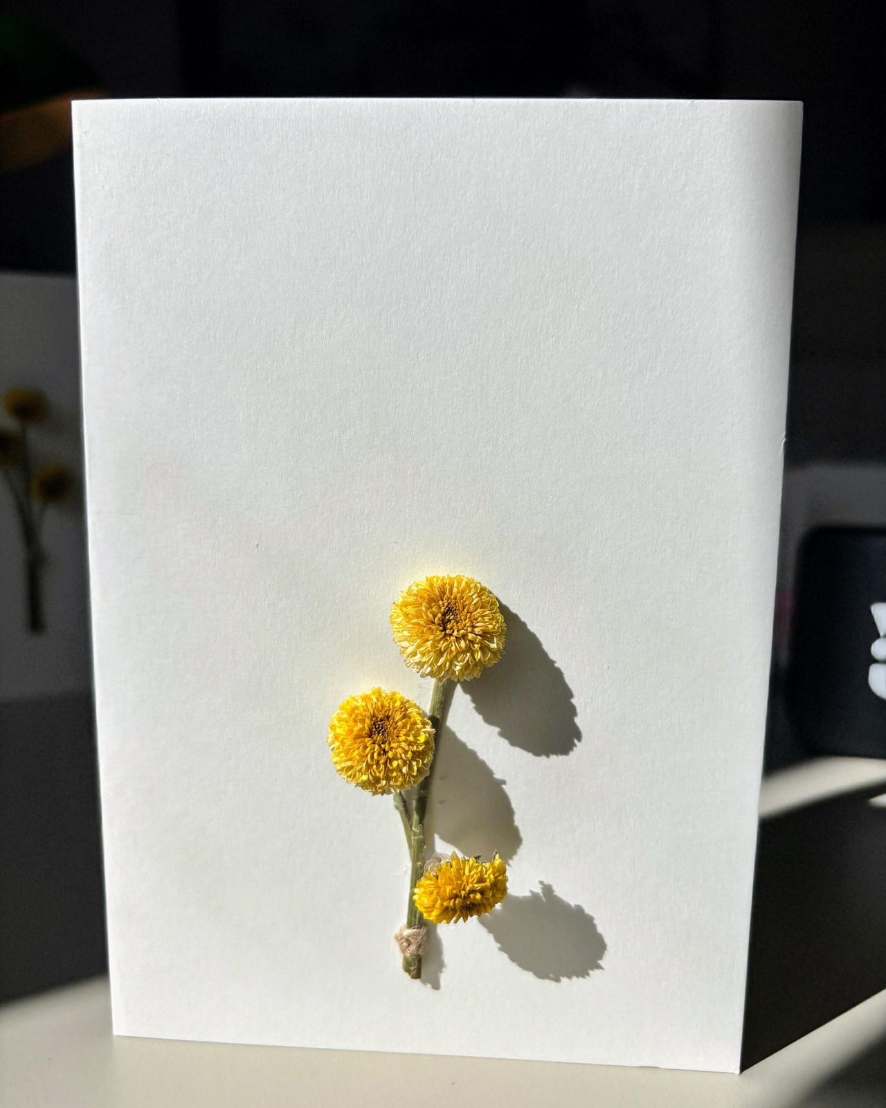 Felicitare artizanală cu mici flori galbene naturale și design elegant