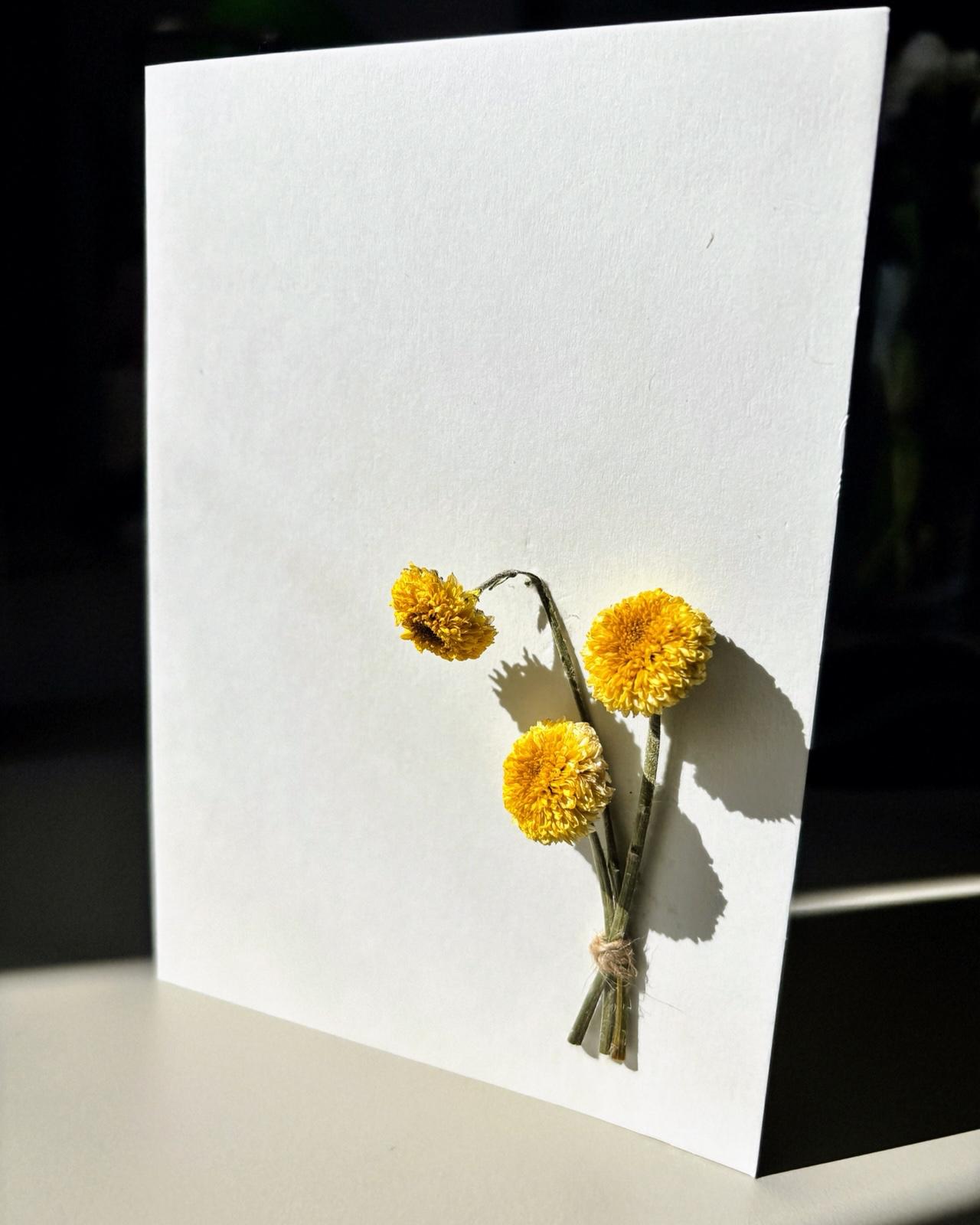 Felicitare minimalistă cu flori galbene presate și lumină naturală