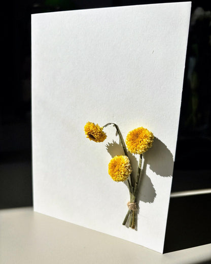 Felicitare minimalistă cu flori galbene presate și lumină naturală